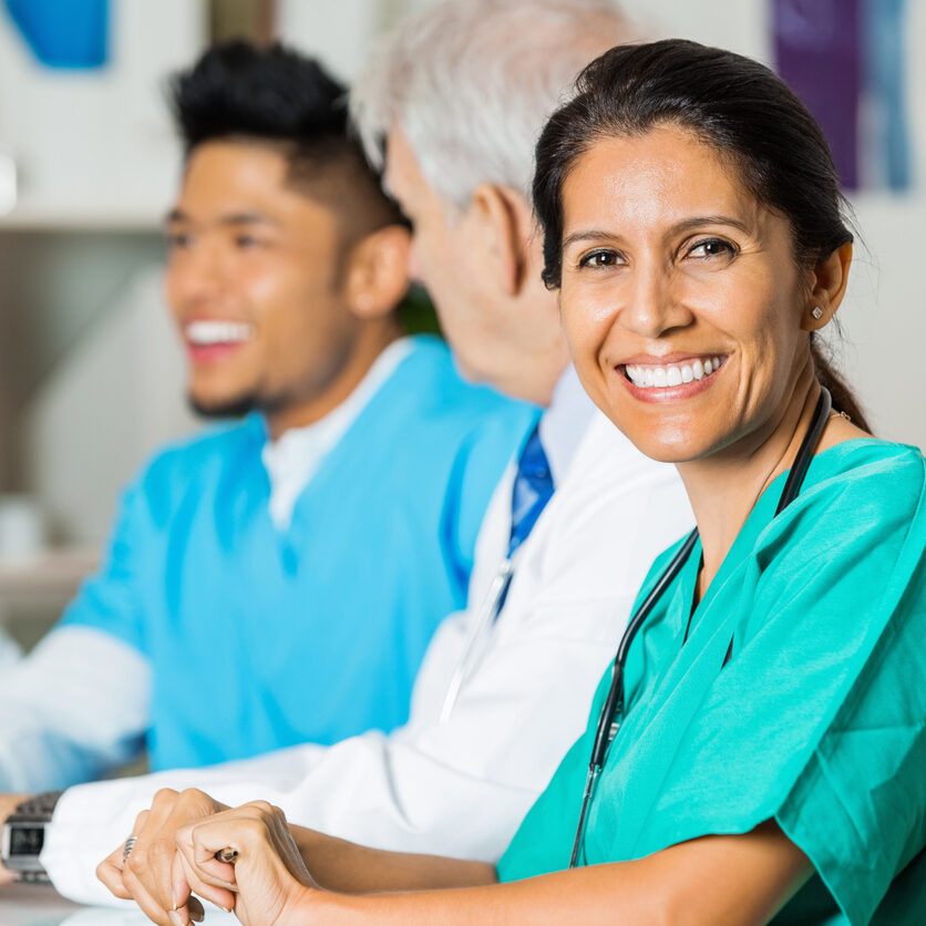Confident Hispanic nurse or doctor in hospital staff meeting